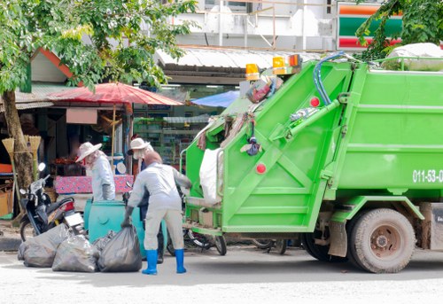 Crew preparing a medium-sized skip for a garden clearance
